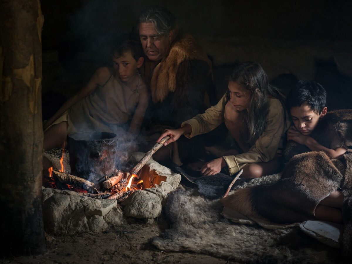 Junge öffnet die gesammelten Haselnüsse mit Hilfe eines Steines<br/> Ragazzo apre le nocciole raccolte con l'aiuto di una pietra<br/>Boy opens the collected hazelnuts with a stone<br/><br/>archeoParc Val Senales